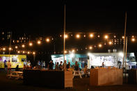 Visitors eat at the Honoapiilani Food Truck Park, Thursday, Dec. 7, 2023, in the beach resort community of Kaanapali in Lahaina, Hawaii. Residents and survivors still dealing with the aftermath of the August wildfires in Lahaina have mixed feelings as tourists begin to return to the west side of Maui. (AP Photo/Lindsey Wasson)