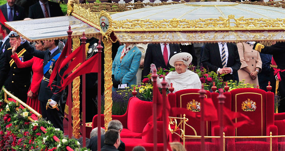 Britain's Queen Elizabeth II waves as she travels aboard the Royal Barge 'Spirit of Chartwell' in the Diamond Jubilee Pageant on the River Thames in London, on June 3, 2012. Hundreds of rowing boats, barges and steamers filled the River Thames with a blaze of colour on Sunday as Queen Elizabeth II sailed through London as part of her spectacular diamond jubilee pageant.  AFP PHOTO / GLYN KIRK        (Photo credit should read GLYN KIRK/AFP/GettyImages)
