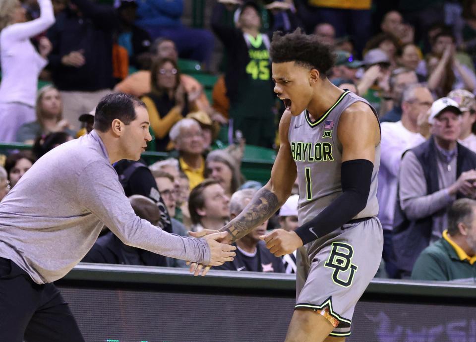 Baylor guard Keyonte George (1) slaps hands with coach Scott Drew after a Baylor score against Oklahoma State during the first half.