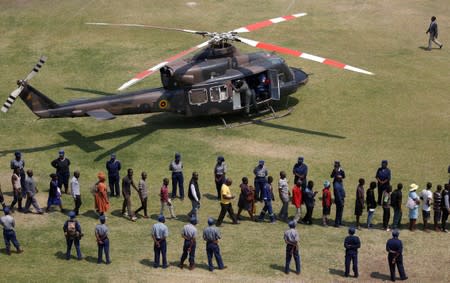 Mourners queue past a military chopper to pay their last respects to Former Zimbabwean president Robert Mugabe as he lies in state at the at Rufaro stadium