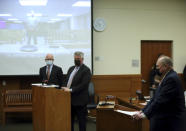 Prosecutor Tim Merkle, right, reads the statement of facts as Jason Meade, left, appearing on video screen, and Defense attorneys Steve Nodler and Mark Collins listen during the arraignment of former Franklin County, Ohio, deputy Meade who was indicted on murder charges in the 2020 shooting death of Goodson in Columbus, Ohio, Friday, Dec. 3, 2021. Meade, who fatally shot Casey Goodson Jr. in the back five times has pleaded not guilty to charges of murder and reckless homicide. (AP Photo/Paul Vernon)