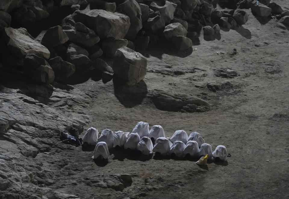 Muslim pilgrims pray on the rocky hill known as the Mountain of Mercy, on the Plain of Arafat, during the annual hajj pilgrimage, near the holy city of Mecca, Saudi Arabia, Friday, July 8, 2022. (AP Photo/Amr Nabil)