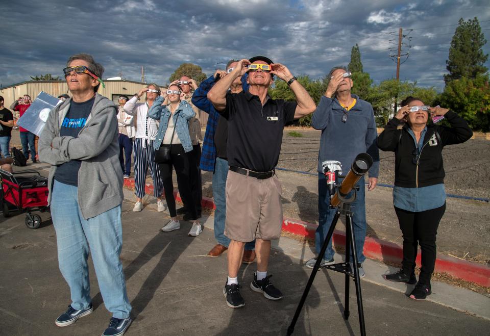 Eclipse watchers look at the sun through special protective glasses during a watch party held by the Delta College Physics-Math-Computer Sciences Club and the the Stockton Astronomical Society on the campus of San Joaquin Delta College in Stockton on Oct. 14, 2023. It began at about 8 a.m. and lasted until about 10:40 a.m. with its peak at about 9:30 a.m. About 50 people attended the event. A solar eclipse is when the moon comes between the Earth and Sun. Stockton was just outside of the eclipse's path and experiences only a partial eclipse covering most but all of the Sun. The Oct. 14 eclipse was an annular eclipse. That's when the moon is at its farthest from the Earth and it doesn't entirely block out the Sun but leaves a ring often called the "ring of fire." A total eclipse will occur on April, 8 2024.