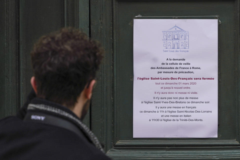 A man reads a note announcing the closing of the St. Louis of the French church in Rome, Sunday, March 1, 2020. The French community church in Rome, St. Louis of the French, closed its doors to the public on Sunday, reportedly after a priest was infected with a new virus. The church in the historic center of Rome is famous for three paintings by the Baroque master Caravaggio, and is a tourist draw. A sign on the door Sunday noted in French that the church had been closed as a precaution by the French Embassy for both Masses and touristic visits until further notice. (AP Photo/Andrew Medichini)