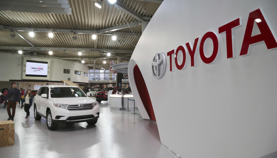 Visitors inspect cars on display at Toyota gallery in Tokyo Tuesday, Feb. 4, 2014. Toyota Motor Corp. reported a more than fivefold jump in its quarterly profit Tuesday and raised its earnings forecast, crediting a weak yen and strong sales. Toyota's profit for the October-December quarter totaled a better-than-expected 525.4 billion yen ($5.2 billion), up dramatically from 99.9 billion yen a year earlier. (AP Photo/Koji Sasahara)