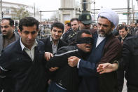 This picture provided by ISNA, a semi-official news agency, taken on Tuesday, April 15, 2014 shows Iranian officials and security escorting away the blindfolded man Bilal from the scene of his execution in public in the northern city of Nour, Iran. Bilal, who was convicted of killing Abdollah Hosseinzadeh, was pardoned by the victim's family moments before being executed. (AP Photo/ISNA, Arash Khamoushi)