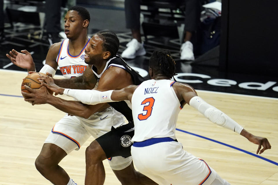 Los Angeles Clippers forward Kawhi Leonard, center, is defended by New York Knicks guard RJ Barrett, left, and center Nerlens Noel (3) during the first half of an NBA basketball game Sunday, May 9, 2021, in Los Angeles. (AP Photo/Marcio Jose Sanchez)