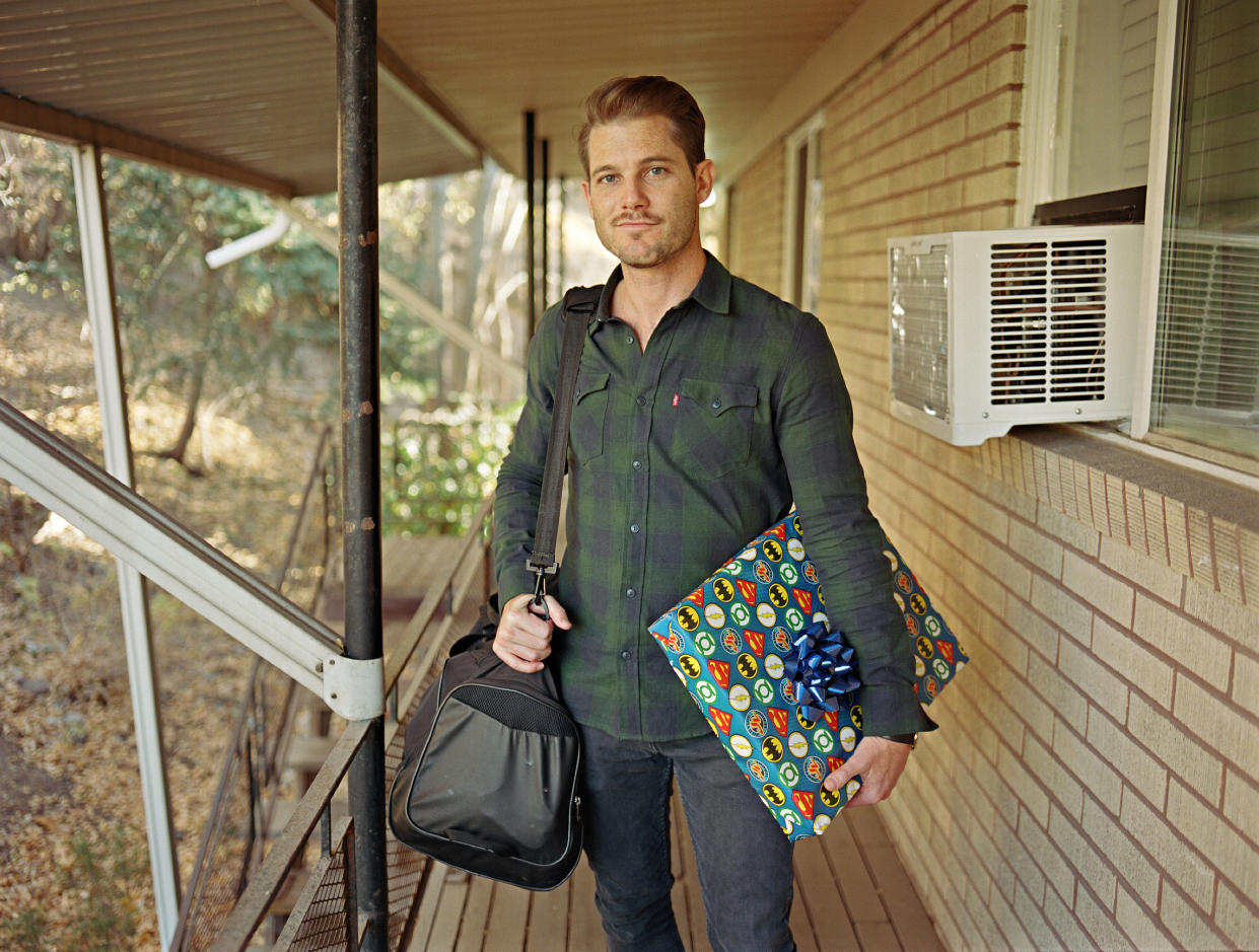 Devon holds a birthday present for his son in front of his apartment in Salt Lake City. (Bart Heynen)