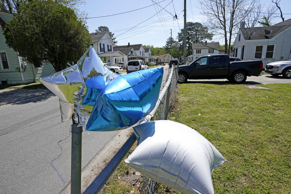 Balloons are seen tied to a fence in Elizabeth City, N.C., Thursday, April 22, 2021 at the scene where a North Carolina deputy shot and killed a Black man while executing a search warrant on Wednesday, authorities said. (AP Photo/Gerry Broome)