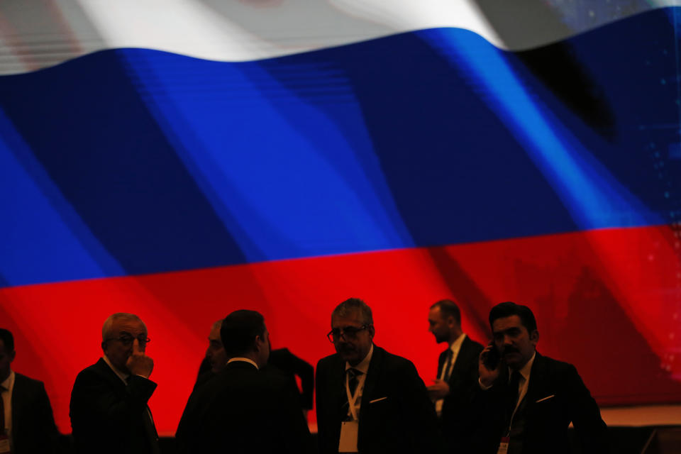 Backdropped by Russia's flag officials wait for an event to be attended by Turkey's President Recep Tayyip Erdogan and Russian President Vladimir Putin, marking the completion of one of the phases of the Turkish Stream natural gas pipeline, in Istanbul, Monday, Nov. 19, 2018. The two 930-kilometer (578-mile) lines when finished are expected to carry 31.5 billion cubic meters (1.1 trillion cubic feet) of Russian natural gas annually to European markets, through Turkish territories.(AP Photo/Lefteris Pitarakis)