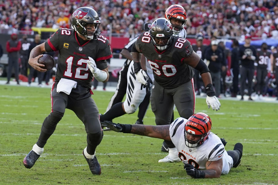 Tampa Bay Buccaneers quarterback Tom Brady (12) scrambles away from Cincinnati Bengals defensive tackle Josh Tupou (68) during the first half of an NFL football game, Sunday, Dec. 18, 2022, in Tampa, Fla. (AP Photo/Chris O'Meara)