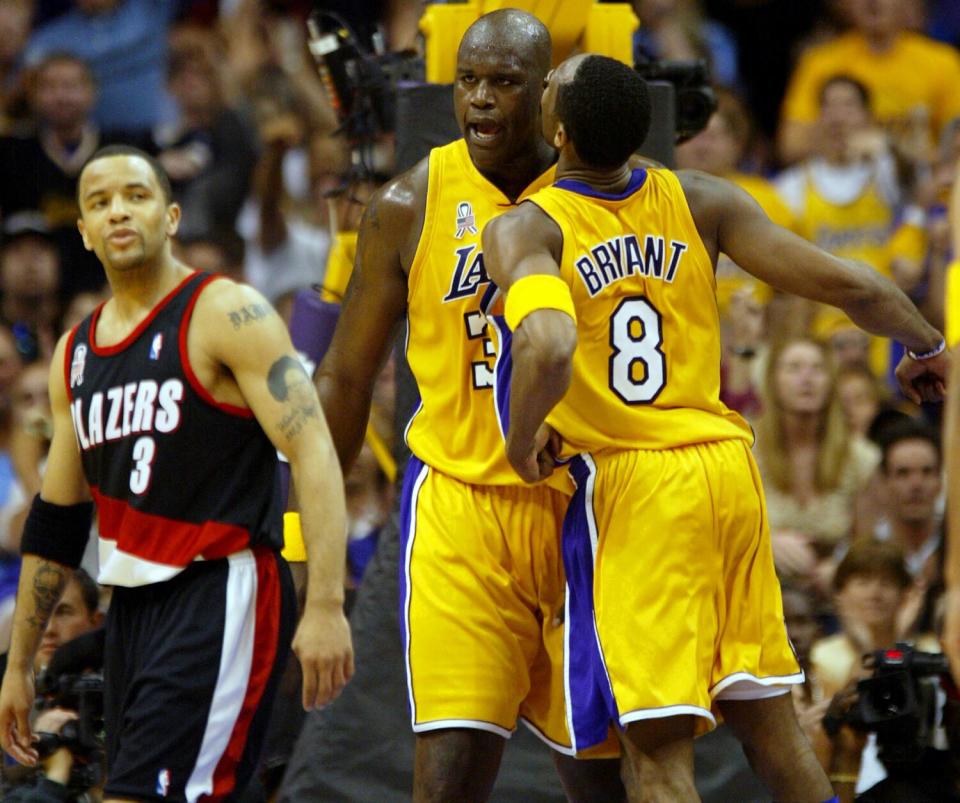 Shaquille O'Neal is chest-bumped by Lakers teammate Kobe Bryant.