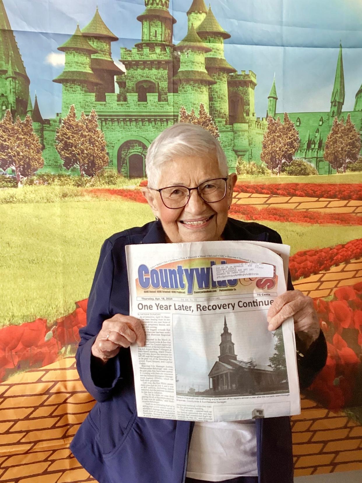 Rosemary Pierce, a resident of Brookdale Shawnee assisted living center, is seen recently in front of an image inspired by the fiction and movie classic "Wizard of Oz," during a party commemorating the one-year anniversary of a tornado that hit portions of Shawnee on April 19, 2023.