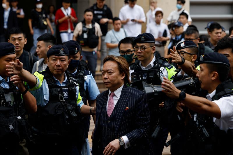 Lawrence Lau Wai-chung is escorted by police outside the West Kowloon Magistrates' Courts building after being acquitted of charges under the national security law, in Hong Kong