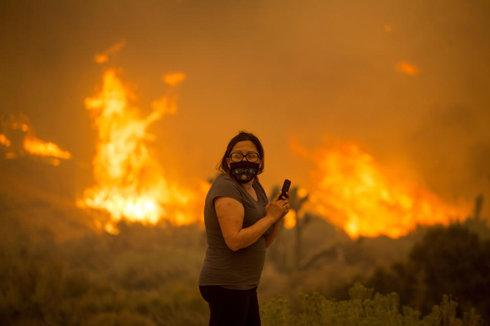 Una mujer observa un incendio forestal en Juniper Hill, California, el viernes 18 de septiembre de 2020. (AP Foto/Ringo H.W. Chiu)