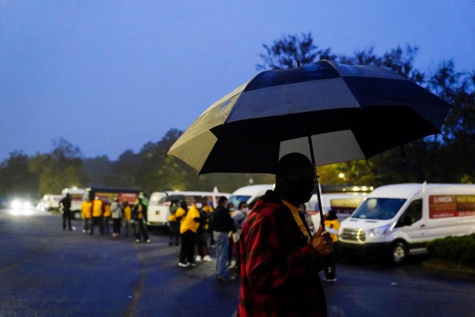 Neighborhood Assistance Corporations of America, or NACA, employees gather in a parking lot for “Roll to the Polls” a daily event to help usher voters to the polls in vans for early voting on Wednesday, Oct. 28, 2020, in Decatur, Ga.