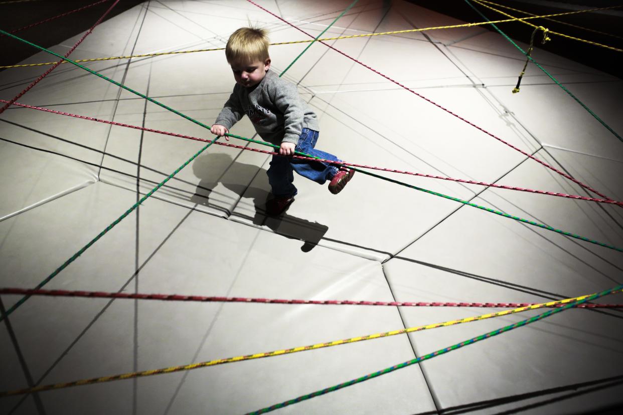 A young child plays in the stretchy rope area inside the Kentucky Science Center's "Science in Play" area.