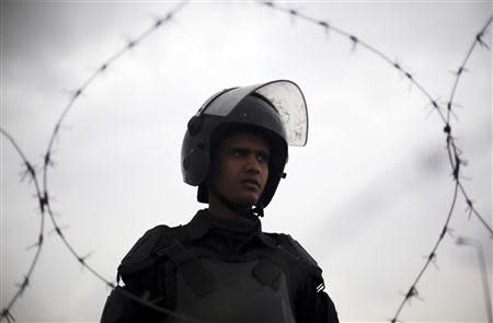 A riot police stands guard outside a police academy, where the trial of ousted Egyptian President Mohamed Mursi and members of the Muslim Brotherhood is due to take place, on the outskirts of Cairo, February 16, 2014. REUTERS/Amr Abdallah Dalsh