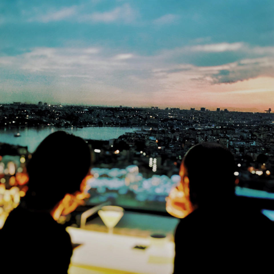 A couple sitting at a restaurant with a view of Istanbul.