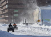 Two all-terrain vehicles cruise through downtown St. John's Newfoundland on Saturday, Jan. 18, 2020. The state of emergency ordered by the City of St. John's is still in place, leaving businesses closed and vehicles off the roads in the aftermath of the major winter storm that hit the Newfoundland and Labrador capital. (Andrew Vaughan/The Canadian Press via AP)