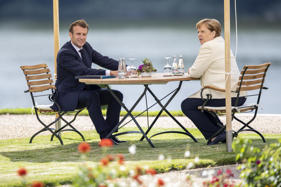 GRANSEE, GERMANY - JUNE 29: German Chancellor Angela Merkel and French President Emmanuel Macron sit in the garden as they meet in the grounds of Schloss Meseberg on June 29, 2020 in Gransee, Germany. The German Chancellor and French President will meet to discuss European Union funding during the Coronavirus pandemic. (Photo by Maja Hitij - Pool / Getty Images)