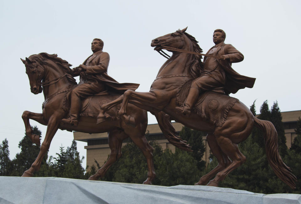 FILE - In this Feb. 14, 2012 file photo, a new bronze statue depicting the late North Korean leader Kim Jong Il, right, and his father Kim Il Sung are seen at stands inside the grounds of the Mansudae Art Studio after it was unveiled in Pyongyang, North Korea. Thousands of government artists work in the huge studio complex to produce everything from propaganda-themed paintings, huge, bronze statues and mosaics to watercolor tigers. The studio is on the U.N. sanctions blacklist and subject to an asset freeze and travel ban because it sends artists and other workers to do projects abroad to generate revenue for the Kim government.(AP Photo/David Guttenfelder, File)