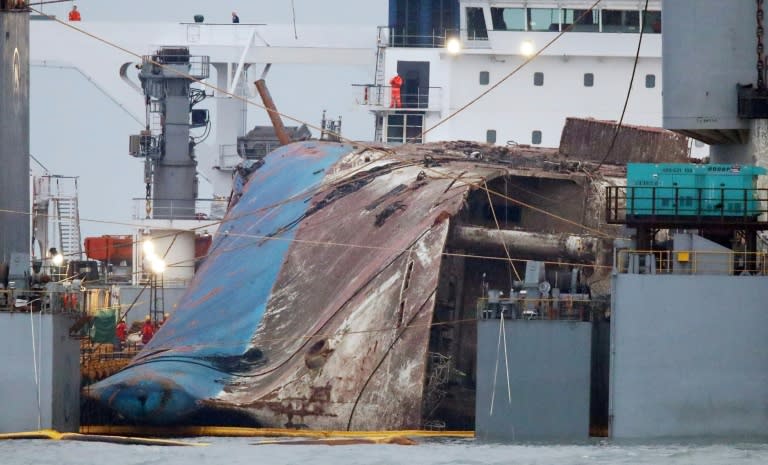 South Korea's sunken Sewol ferry is hauled onto a giant heavy lifting ship ready to be towed from its watery grave