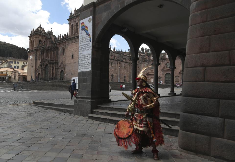 A man dressed as Inca ruler Manco Capac, who according to some historians was the first governor and founder of the Inca civilization in Cusco waits for tourists on an empty street in modern-day Cusco, Peru, Monday, Oct. 26, 2020. All major sites around the Cusco are currently open for free, in hopes of sparking any tourism after the COVID-19 pandemic brought it to a standstill, leaving reenactors like this man interpreting Manco Capac facing severe unemployment. (AP Photo/Martin Mejia)