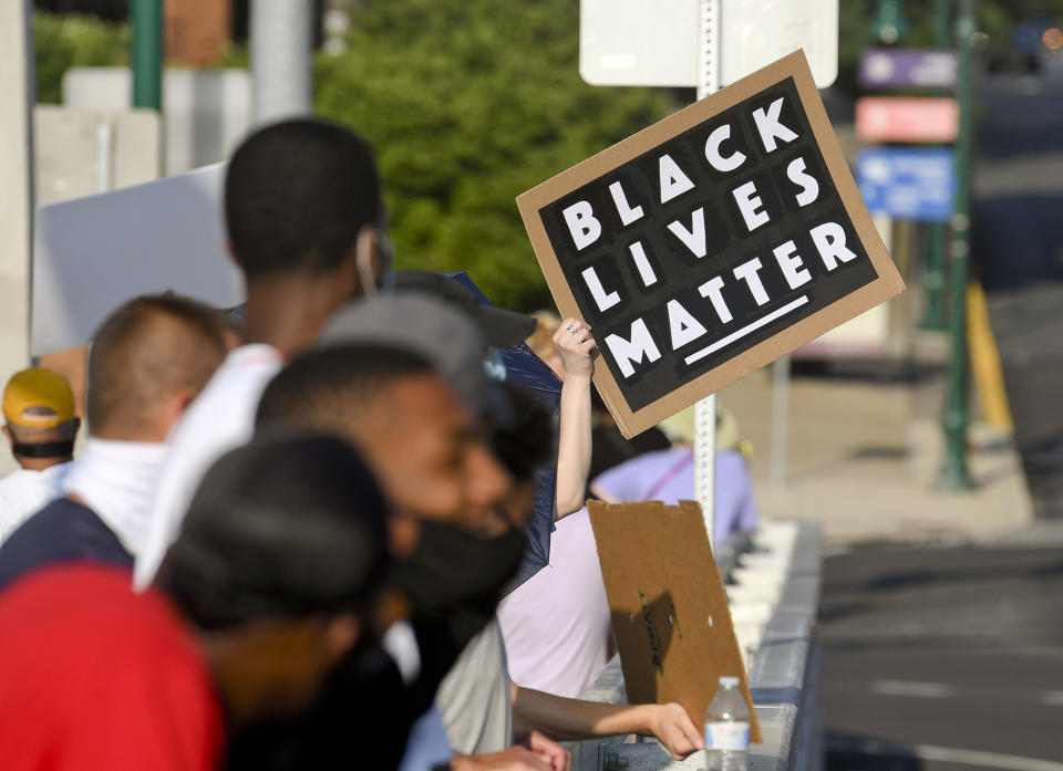 Reading, PA - July 9: A protester holds a sign that reads "Black Lives Matter" along with other protesters on the bridge holding signs during the Peaceful Stand at the Penn Street Bridge in Reading Thursday evening July 9, 2020. The event was organized by Muhlenberg boys basketball coach and retired NBA player Tyrone Nesby and Friends, and is intended to take a stand against systemic racism and police brutality. This is the third time the Peaceful Stand has been held. Most of the protesters wore face masks as a precaution against the spread of coronavirus / COVID-19. (Photo by Ben Hasty/MediaNews Group/Reading Eagle via Getty Images)