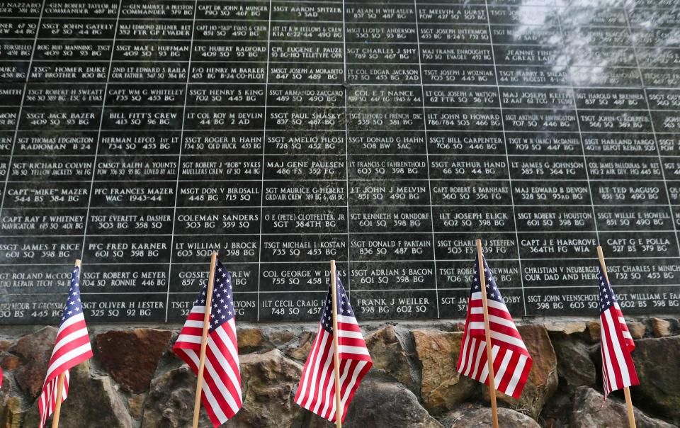 Flags line the walkway under a wall containing the names of members of the Mighty 8th Airforce who died during WWII. 26,000 flags are being placed throughout the garden at the National Museum of the Mighty 8th Air Force for Memorial Day weekend.