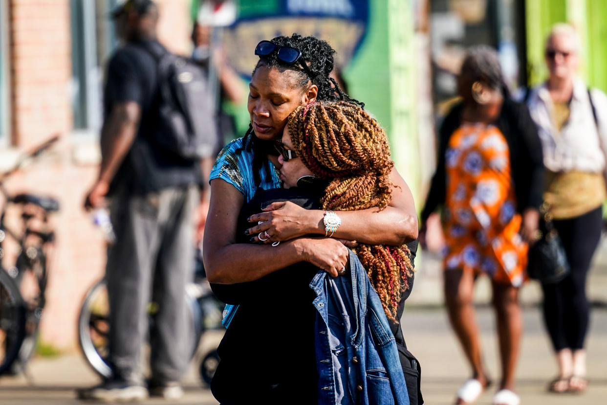 People embrace outside the scene of a shooting at a supermarket in Buffalo, N.Y., on May 15, 2022. (Matt Rourke / AP)