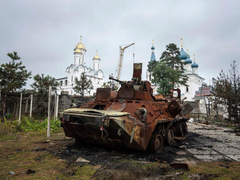 A destroyed Russian APC stands in the yard of a privet house in front of a church in the recently liberated town of Sviatohirsk, Ukraine, Sunday, Oct. 2, 2022.