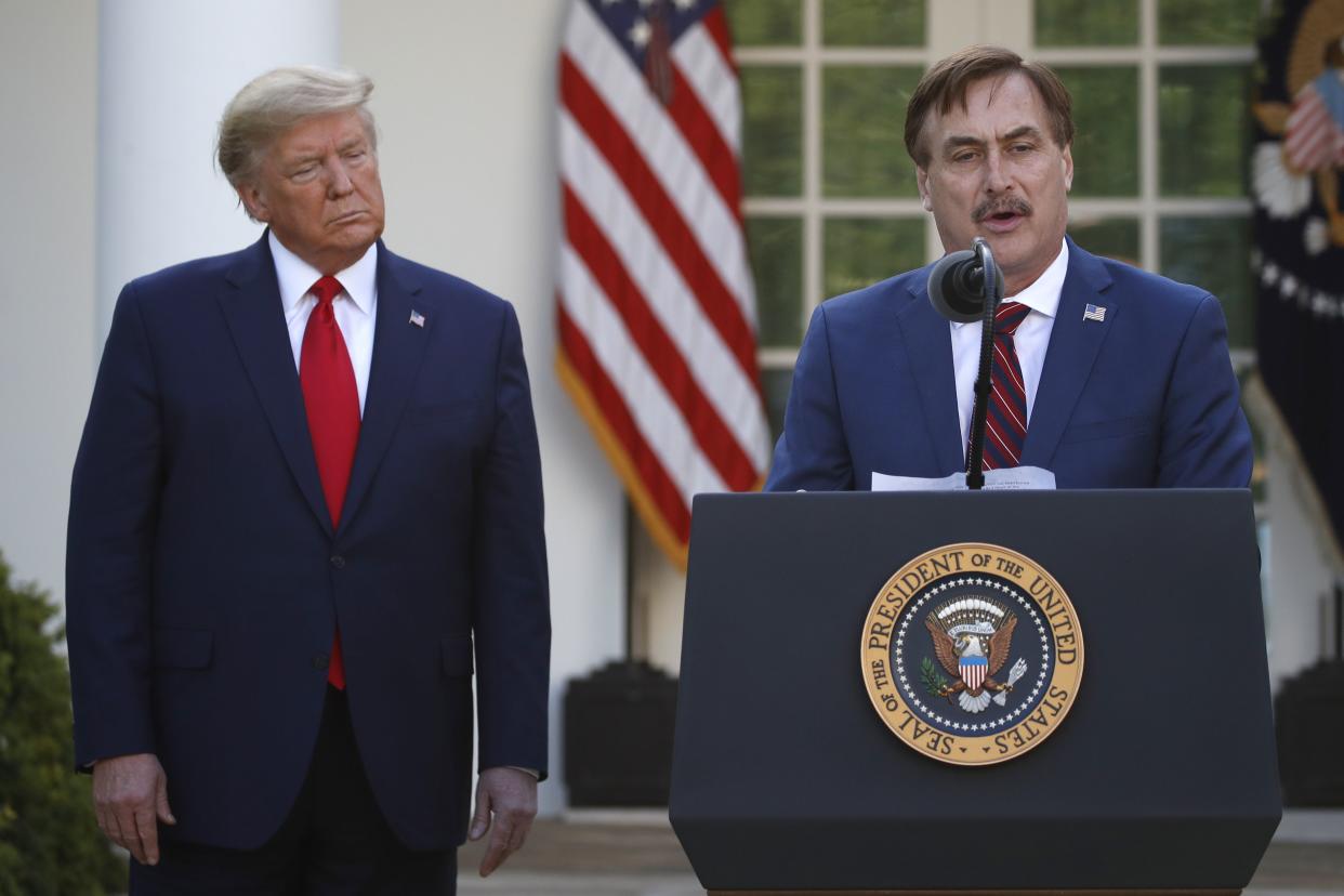 In this March 30, 2020 photo, My Pillow CEO Mike Lindell speaks as then-President Donald Trump listens during a briefing about the coronavirus in the Rose Garden of the White House.