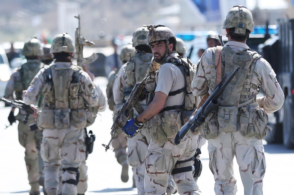 Afghan special forces soldiers arrive at the site of a gun battle between Afghan security forces and insurgents in an Independent Elections Commission (IEC) office in Kabul, Afghanistan, Tuesday, March 25, 2014. Gunmen stormed into the building, trapping dozens of employees inside and killing four people. A candidate for a seat on a provincial council was among those killed, along with an election worker, a civilian and a policeman.(AP Photo/Massoud Hossaini)