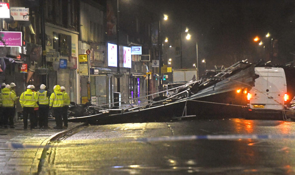 Construction workers in Slough high street after a roof was blown off a building onto the road amid strong winds which have battered parts of the UK.