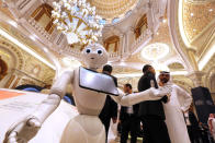 A robot welcomes participants to the Future Investment Initiative forum, "FII" during the opening session in Riyadh, Saudi Arabia, Tuesday, Oct. 29, 2019. The three-day forum, beginning on Tuesday, hosts financiers, governments, and industry leaders who would discuss global trade and explore the trends, opportunities, and challenges shaping the global investment landscape over the coming decades. (AP Photo/Amr Nabil)