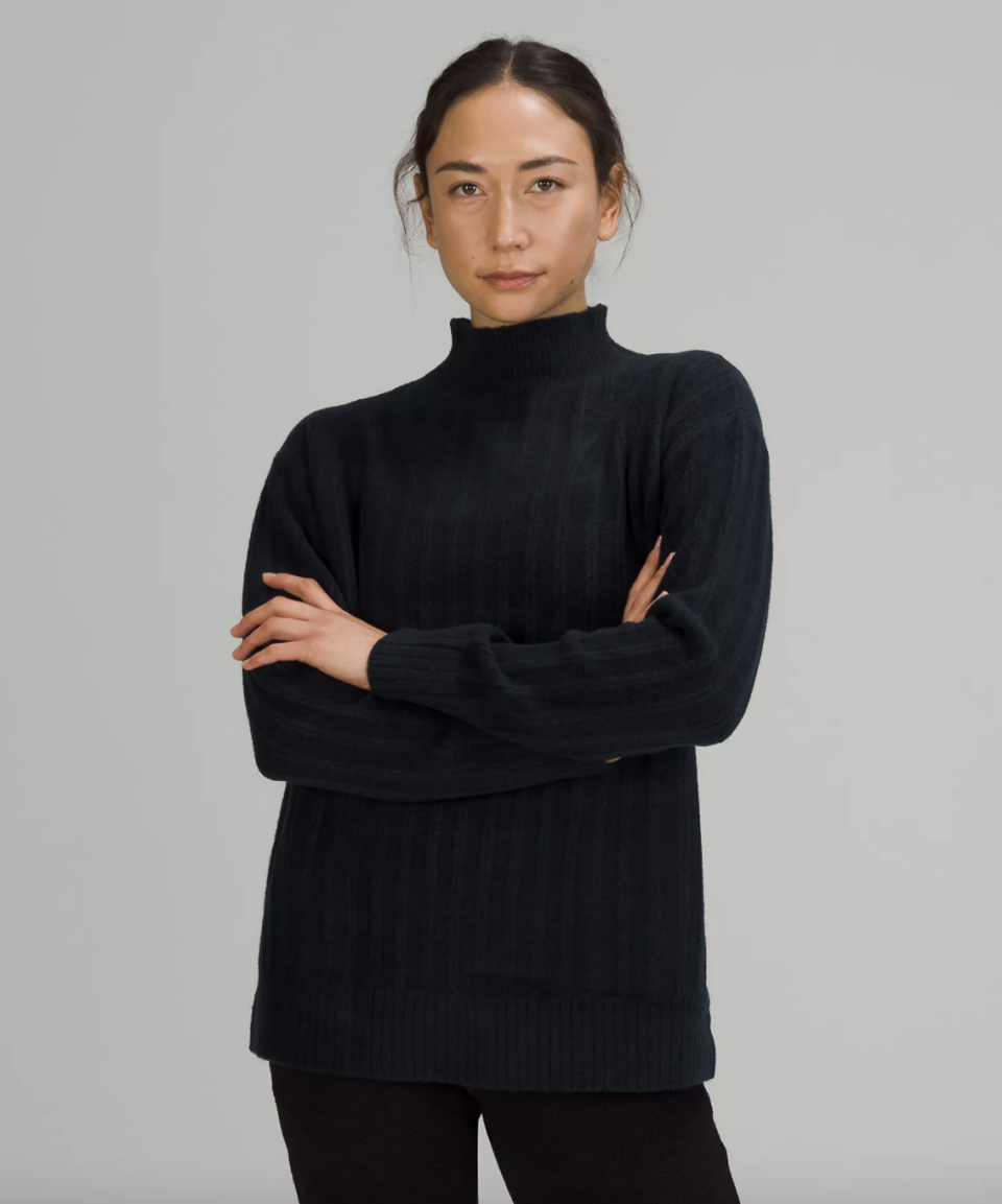 Lululemon Twin Rib Turtleneck Sweater in dark navy blue with black pants (Photo via Lululemon)