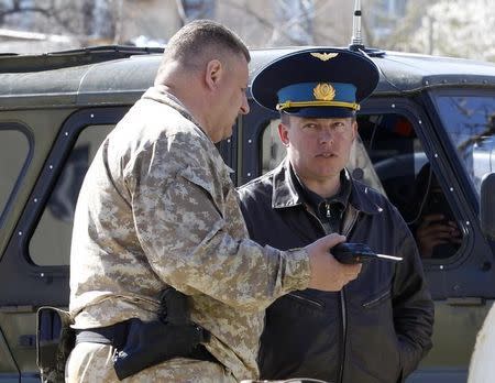 A Russian military officer (L) talks to Ukrainian Colonel Yuli Mamchur (L), demanding Ukrainian servicemen leave a military base in the Crimean town of Belbek near Sevastopol March 22, 2014. REUTERS/Vasily Fedosenko