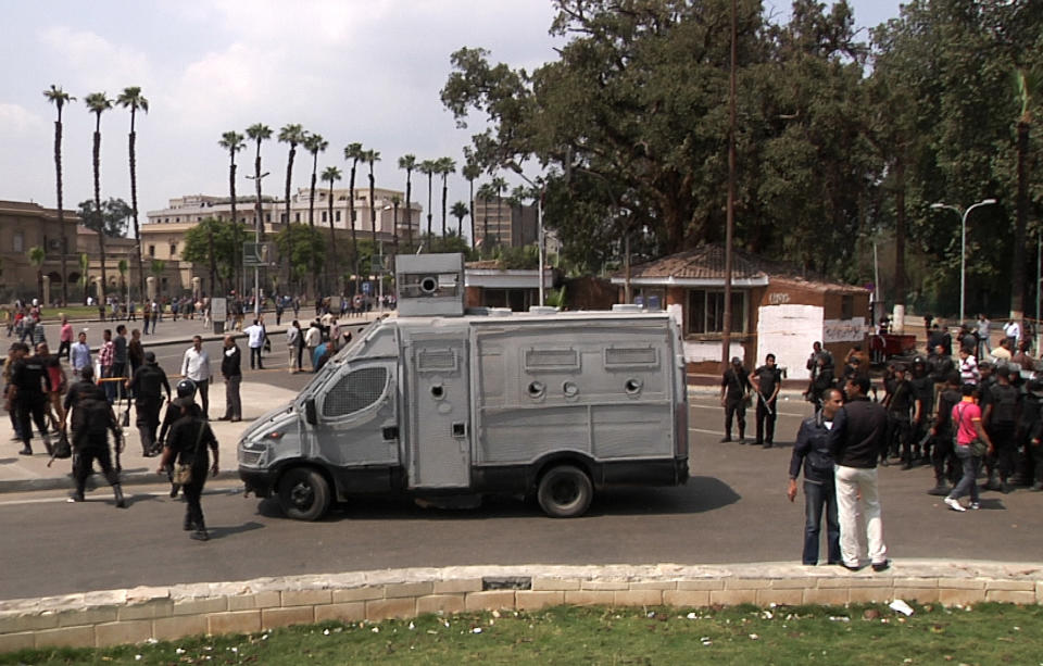 In this image taken from AP Television, Egyptian security forces inspect the scene after multiple explosions hit the area outside the main campus of Cairo University, killing at least two, in Giza, Egypt, Wednesday, April 2, 2014. The bombings targeted riot police routinely deployed at the location in anticipation of near-daily protests by students who support ousted Islamist President Mohammed Morsi and his Muslim Brotherhood group. (AP Photo/AP Video)
