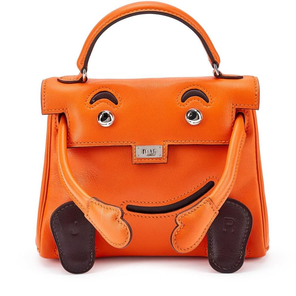 Orange Hermes Birkin bag with face and feet attached