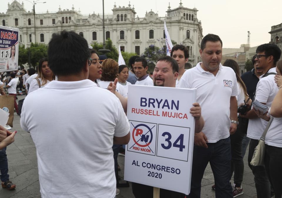 In this Dec. 13, 2019 photo, congressional candidate Bryan Russell, who has Down syndrome, campaigns amid others from his party at San Martin Plaza in Lima, Peru. “I want people with my condition to have a voice,” said Russell, who studied communications at the Peruvian San Ignacio de Loyola university and said his parents encouraged him to find his own way. (AP Photo/Martin Mejia)