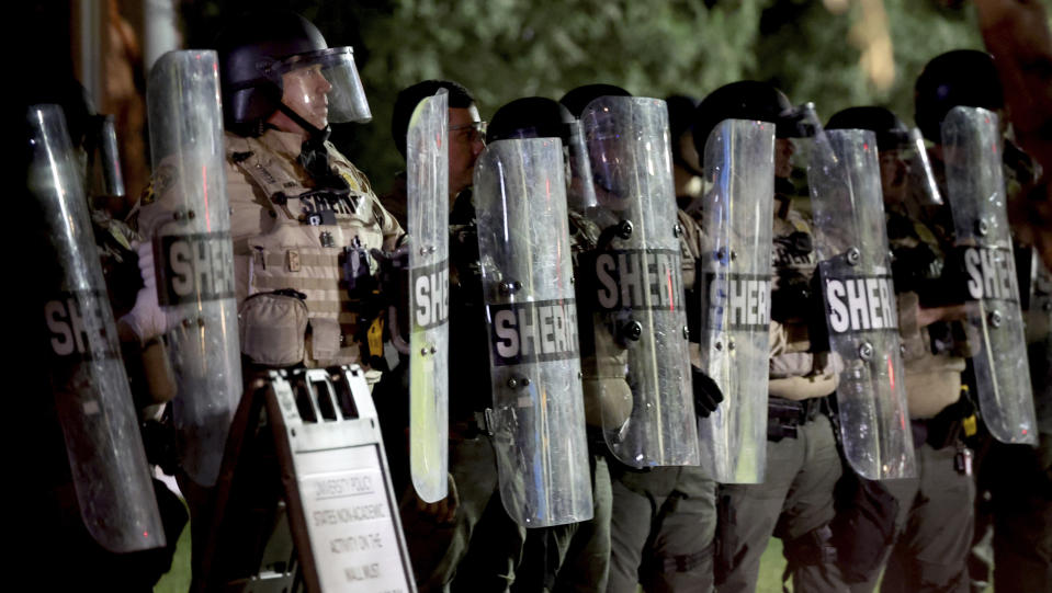 A line of Pima County Sheriff's deputies form a shield line as law enforcement gathers outside an encampment of pro-Palestinian protesters encamped on the University of Arizona campus, early Wednesday, May 1, 2024 in Tucson, Ariz. (Kelly Presnell/Arizona Daily Star via AP)