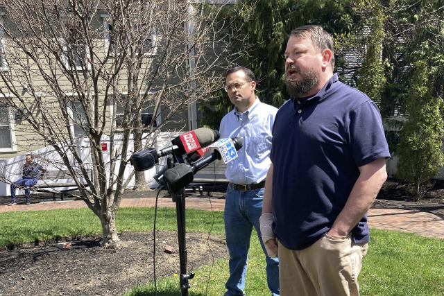 Sean Halsey, right, who was injured along with his children in a shooting in Maine last week, speaks at a news conference outside Maine Medical Center in Portland, Maine, Friday, April 28, 2023. Halsey said he and his children are recovering from their injuries and grateful for the support they've received from the community. A 34-year-old man confessed last week to four killings at a home in Bowdoin and injuring the three people while shooting at vehicles on Interstate 295 in Yarmouth, police have said. (AP Photo/Patrick Whittle)