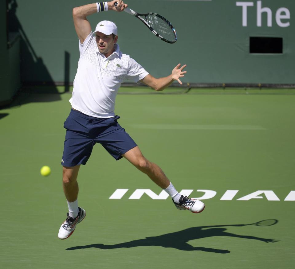 Julien Benneteau, of France, volleys with Novak Djokovic, of Serbia, in their quarterfinal match at the BNP Paribas Open tennis tournament, Friday, March 14, 2014, in Indian Wells, Calif. (AP Photo/Mark J. Terrill)