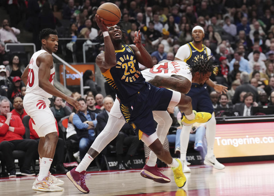Indiana Pacers forward Aaron Nesmith (23) is tripped by Toronto Raptors center Malik Williams (35) during the first half of an NBA basketball game in Toronto on Tuesday, April 9, 2024. (Nathan Denette/The Canadian Press via AP)