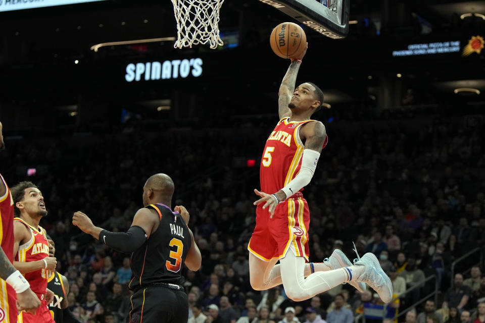 Atlanta Hawks guard Dejounte Murray (5) dunks over Phoenix Suns guard Chris Paul during the first half of an NBA basketball game, Wednesday, Feb. 1, 2023, in Phoenix. (AP Photo/Rick Scuteri)