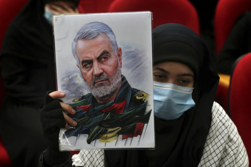 A woman holds up a picture of the head of Iran's Quds force General Qassem Soleimani, who was killed in a U.S. drone strike in Baghdad, during a ceremony to mark the second anniversary of his assassination, in the southern Beirut suburb of Dahiyeh, Lebanon, Monday, Jan. 3, 2022. (AP Photo/Bilal Hussein)