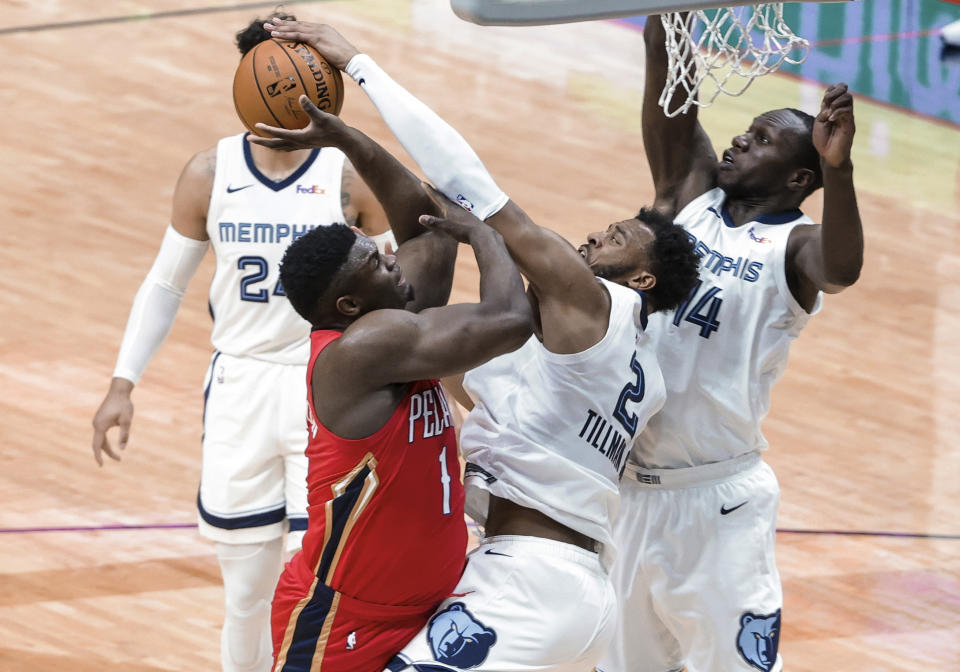 New Orleans Pelicans forward Zion Williamson (1) is fouled by Memphis Grizzlies forward Xavier Tillman (2) while shooting during the first quarter of an NBA basketball game in New Orleans, Saturday, Feb. 6, 2021. (AP Photo/Derick Hingle)