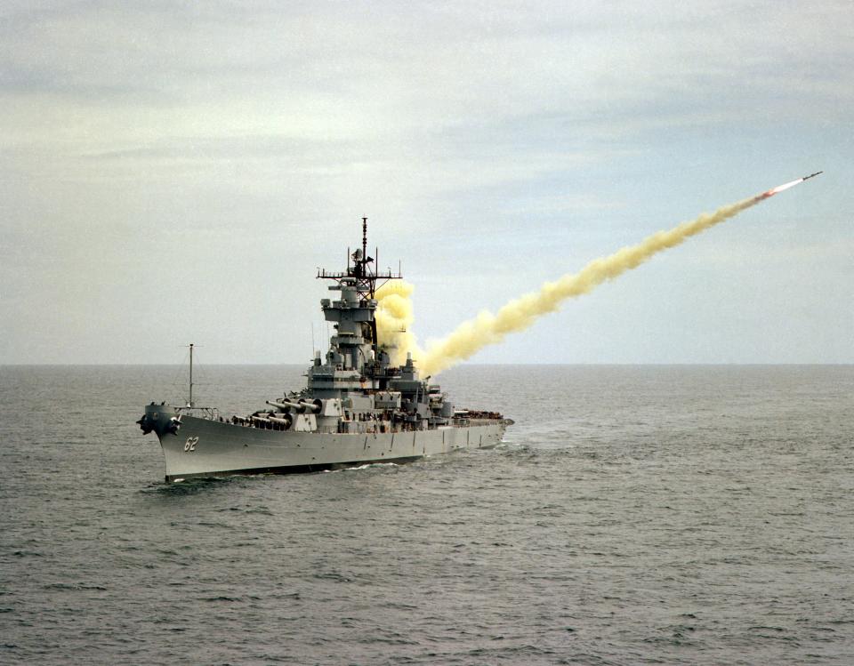 An aerial port bow view of the battleship USS New Jersey launching an RGM-84 Harpoon missile