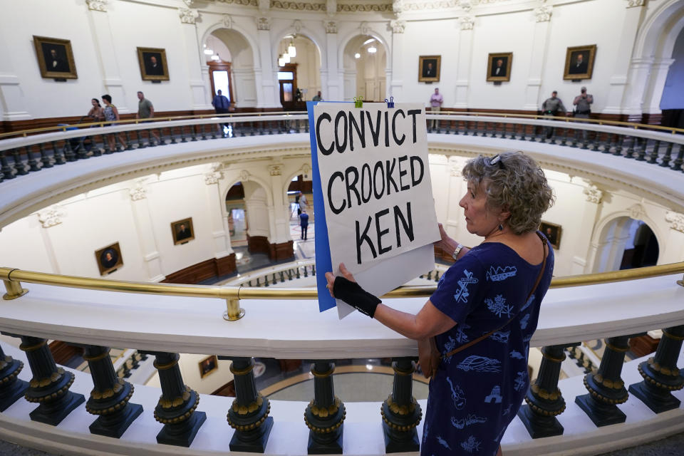 Ellen McCluskey holds a sign outside the Senate Chamber as the impeachment trial for suspended Texas Attorney General Ken Paxton continues at the Texas Capitol, Thursday, Sept. 14, 2023, in Austin, Texas. (AP Photo/Eric Gay)